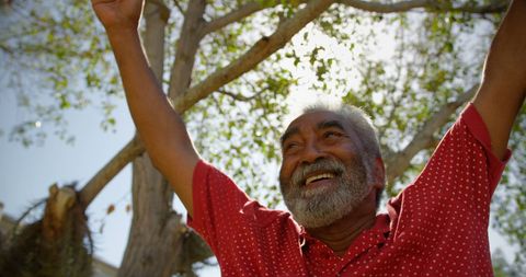 Joyful Senior Man Performing Yoga Outdoors on Sunny Day