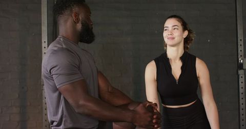 Personal Trainer Demonstrates Quadriceps Stretch in Gym