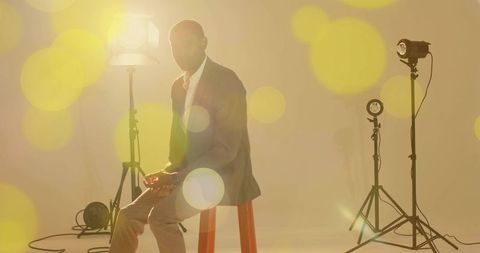 Model Wearing Gray Blazer Posing on Red Stool in Studio Lighting