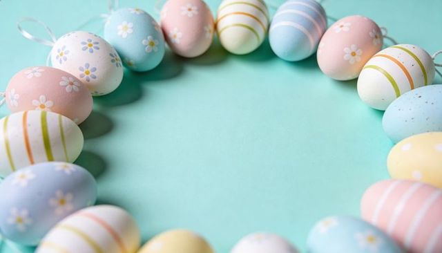 Forming pastel easter egg wreath on mint surface with floral and striped patterns