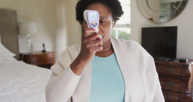 African American Woman Using Infrared Thermometer at Home - Download Free Stock Images Pikwizard.com