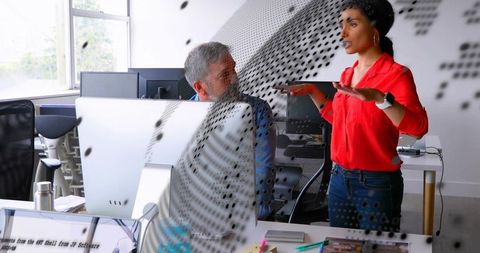 Dynamic office discussion beside curved monitor