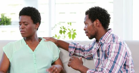 Supportive Man Comforting Upset Woman on Couch