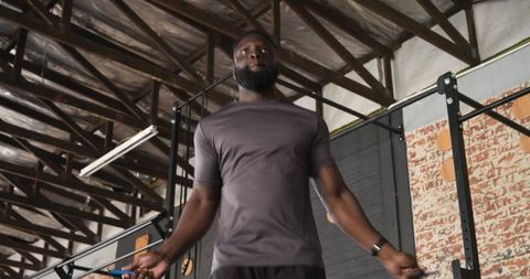 Athletic man jumping rope for cardio workout in gym