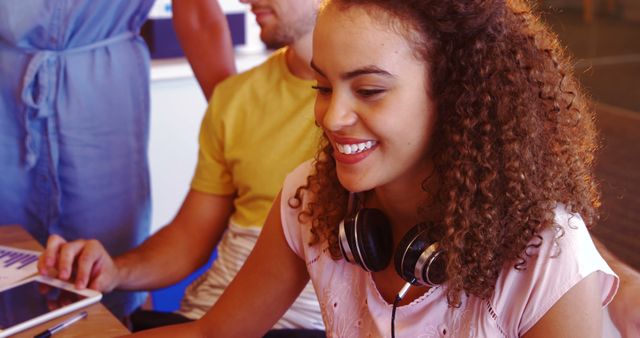 Young Woman Smiling and Working on Computer with Friends - Download Free Stock Images Pikwizard.com