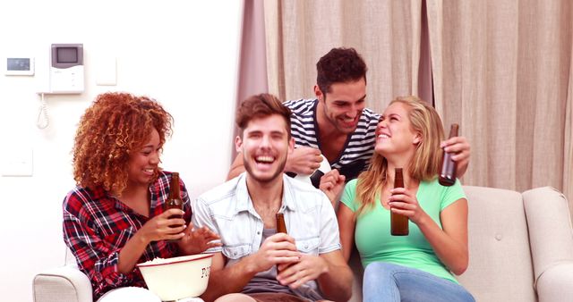 Group of friends enjoying their time and bonding while drinking beverages on a cozy couch. Perfect for use in advertisements or articles about friendship, social gatherings, leisure time, and indoor activities. Suitable for promoting events, social apps, or lifestyle branding.