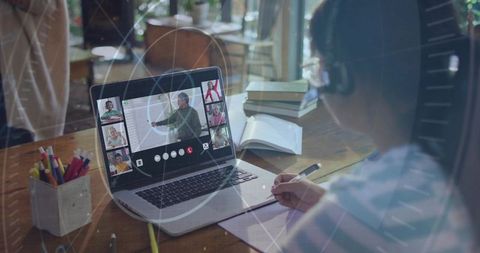 Girl Taking Notes During Virtual Classroom on Laptop at Wooden Desk for Remote Learning