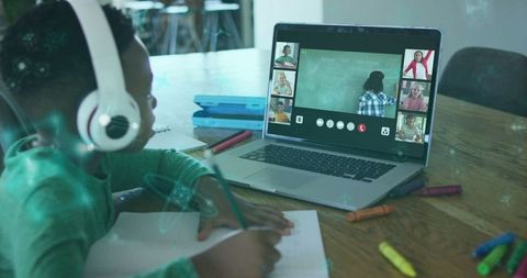 Young student engaging in online class with headphones at home