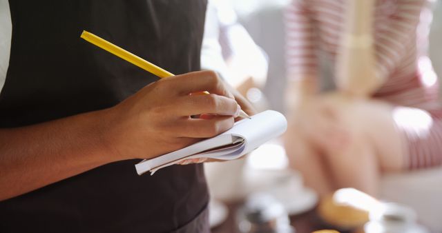 Close-up of Waiter Writing Down Order with Pencil in Notepad - Download Free Stock Images Pikwizard.com