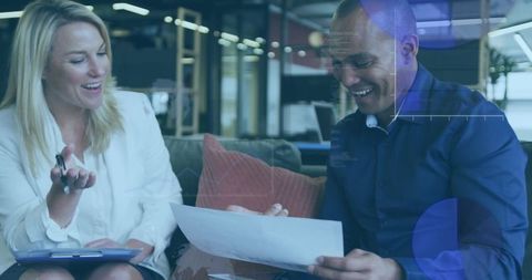 Diverse colleagues discussing financial data with digital graphs