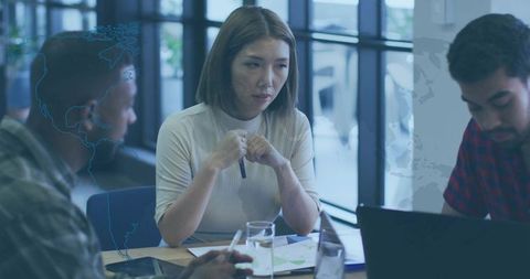 Diverse Team in Office Meeting Collaborating with Laptops and Documents