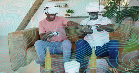 Friends playing virtual reality games on sofa with controllers, vr headsets and snacks