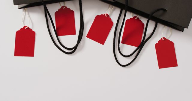Two black gift bags with five red sale tags on white background with copy space - Download Free Stock Photos Pikwizard.com