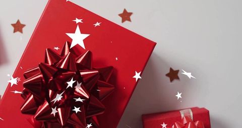 Festive glossy red gift box with metallic star bow and gold star confetti for holiday campaigns