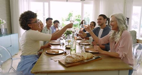 Diverse group sharing meal and toasting together
