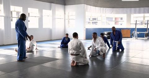 Diverse martial arts group practicing in well-lit gym