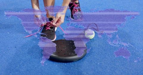 Tying pink-laced sneaker on blue court using balance trainer and tennis ball