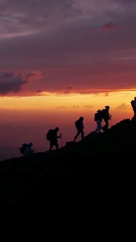 Sunset Ridge Trek: Hikers Ascending Silhouette Line at Dusk, Vertical Adventure Video