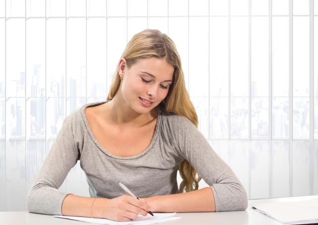 Teenage girl happily studying in a bright classroom, writing on paper with a pen. Ideal for educational content, school promotions, student life articles, and academic success stories.