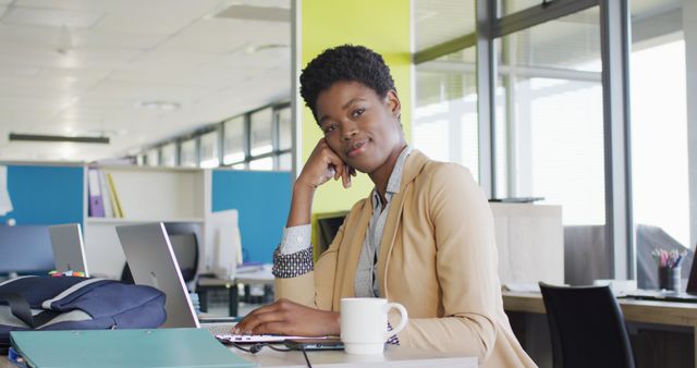 Portrait of happy african american businesswoman using laptop at office. Business, corporation, working in office and cooperation concept.