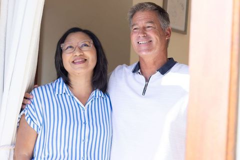 Senior couple enjoying sunny doorway moment sharing warmth and companionship at home