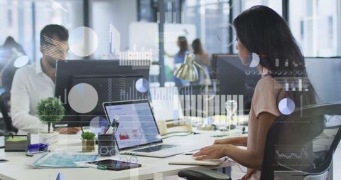Business professionals analyzing data on computers in modern office