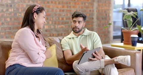 Colleagues Collaborating on Tablet in Modern Office Space