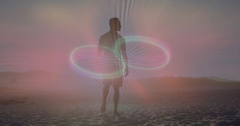 Man standing on beach watching dawn with glowing neon infinity ring