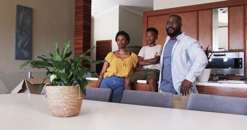 African American Family Unpacking in Modern Open-Plan Kitchen Posing with Houseplants