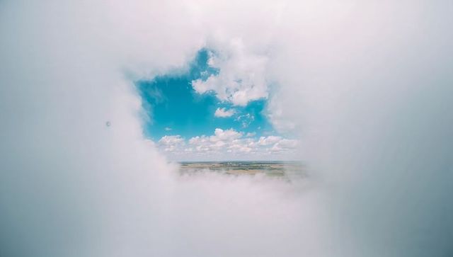 Clouds Parting to Reveal Clear Blue Sky and Horizon