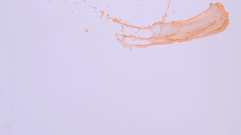 Red Liquid Splattering on Clean White Background
