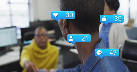 Digital Social Media Icons Hovering Over Colleagues Collaborating in Office