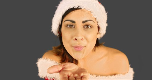 Festive Woman Blowing Kiss Wearing Santa Hat And Off-Shoulder Top - Download Free Stock Images Pikwizard.com