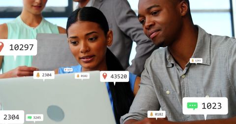 Diverse Colleagues Analyzing Data on Laptop with Virtual Notifications