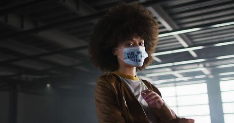 African American Woman Wearing Protest Mask in Urban Garage