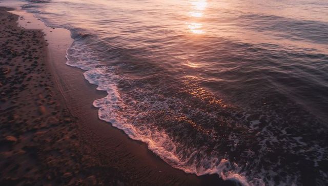 Waves Rolling Over Wet Sand with Golden Sunset Reflection