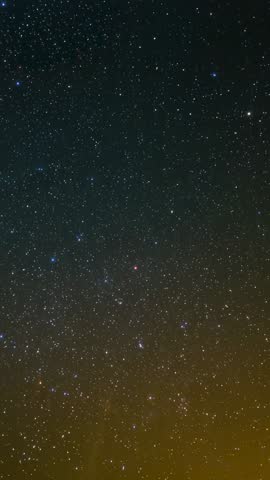 Vertical video capturing starry night sky with horizon glow over rural landscape