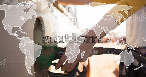 Hand holding fuel nozzle at station with world map overlay