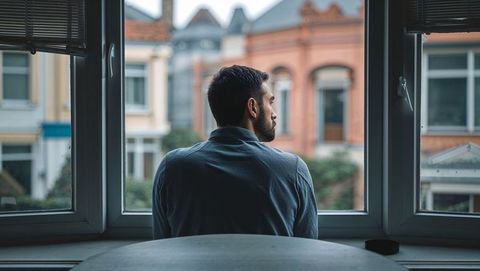 Man Sheltering in Cozy Apartment Gazing Out Large Window