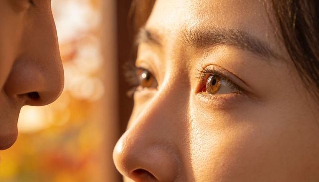 Intimate close-up woman gazing into partner eyes during golden hour glow