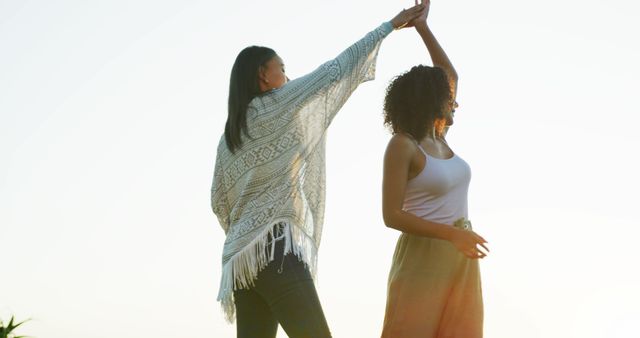 Two women dancing outdoors at sunset enjoying life - Download Free Stock Images Pikwizard.com