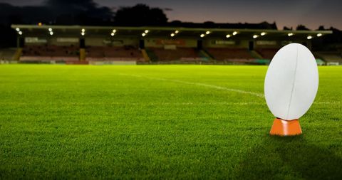 Rugby Ball on Green Field with Stadium Background at Night - Download Free Stock Images Pikwizard.com