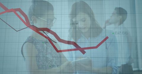 Businesswomen analyzing financial data on tablet in office setting