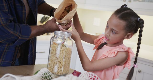 Father and Daughter Storing Dry Pasta in Kitchen - Download Free Stock Images Pikwizard.com