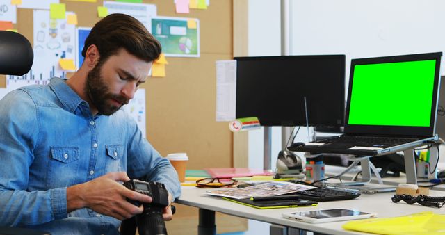 Photographer in a Modern Office Checking Camera Settings - Download Free Stock Images Pikwizard.com