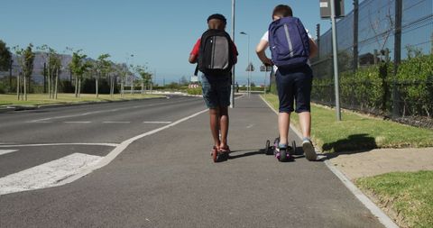 Children Riding Scooters to School on Sunny Day