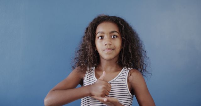 Young Girl Learning Sign Language Against Blue Background - Download Free Stock Images Pikwizard.com