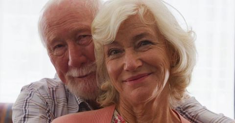 Senior Caucasian Couple Embracing at Home Smiling Together