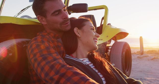 Couple enjoying a peaceful sunset by a yellow dune buggy on a beach. Ideal for travel advertisements, romantic getaway promotions, outdoor lifestyle content, and love-themed marketing. Captures the essence of relaxation, adventure, and romance.