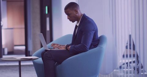 Business Professional Typing on Laptop in Modern Corporate Lounge